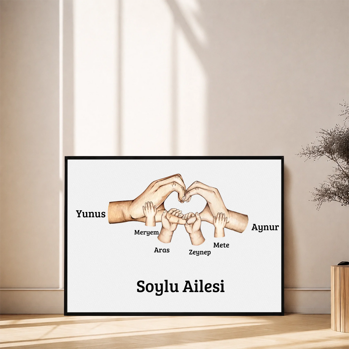 Kişiye Özel Aile El İzi Tablosu – çocuk el izleri ve isimlerinin yer aldığı tasarım, siyah çerçeveli tablo, duvara yaslı
