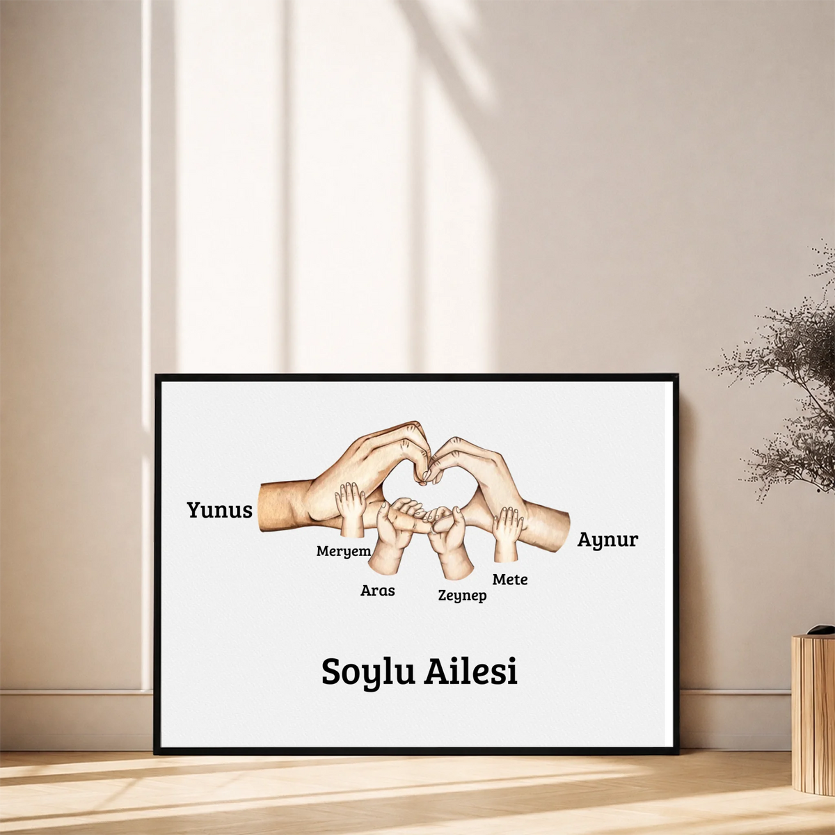 Kişiye Özel Aile El İzi Tablosu – çocuk el izleri ve isimlerinin yer aldığı tasarım, siyah çerçeveli tablo, duvara yaslı